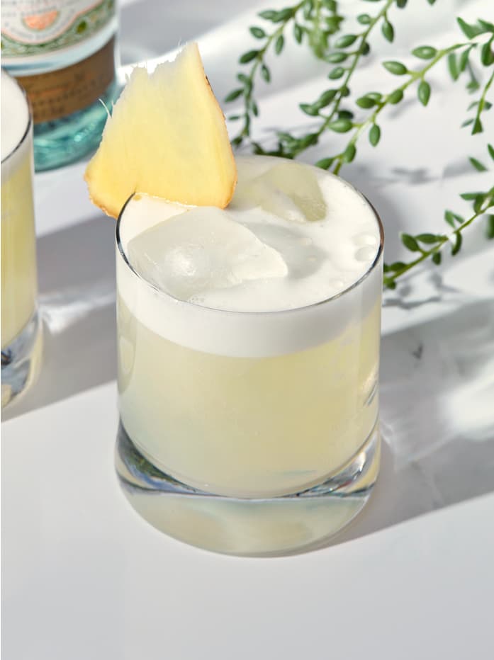 A close up of a Tanqueray Rangpur Bees Kees cocktail sitting on a table.