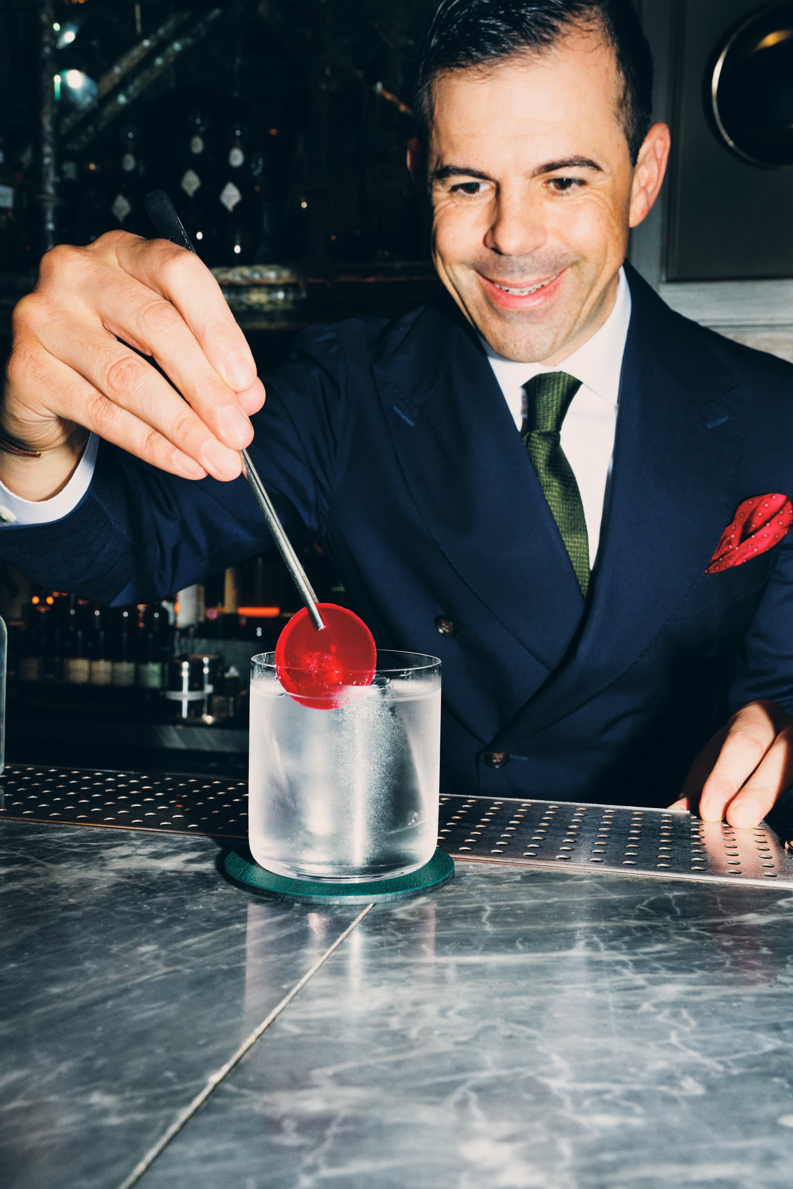 Ago Perrone placing a sun dried tomato/mirto distillate garnish into a Gin Rickey cocktail