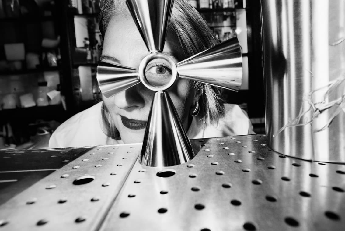 Giulia Cuccurullo behind a bar looking through a jigger